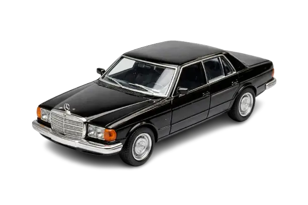 Classic black luxury sedan on a black background, featuring a chrome grille and headlights. The car exudes a vintage, elegant appeal.